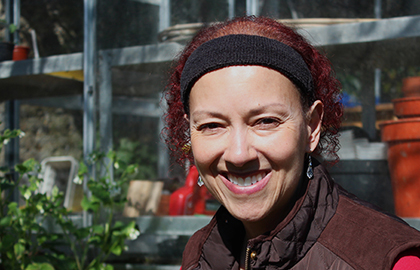 Close up photo of a volunteer smiling, set in a garden location