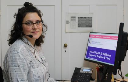 Photo of Community navigator sitting at a computer screen with a headset on
