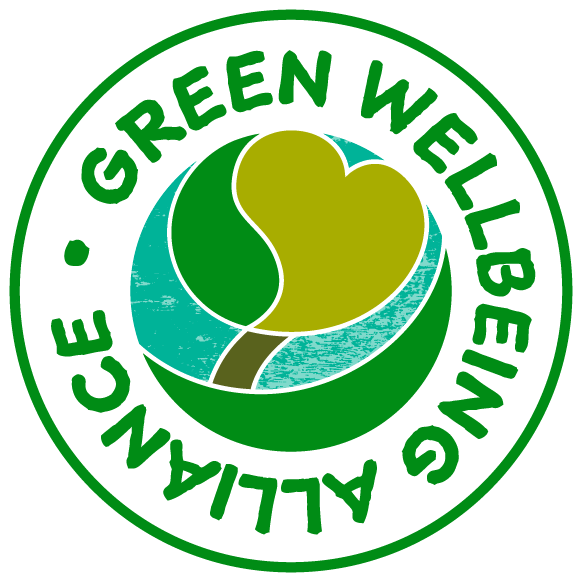 A green crcular logo showing an illustration of a tree with a green heart shape. The words around the edge read 'Green Wellbeing Alliance'