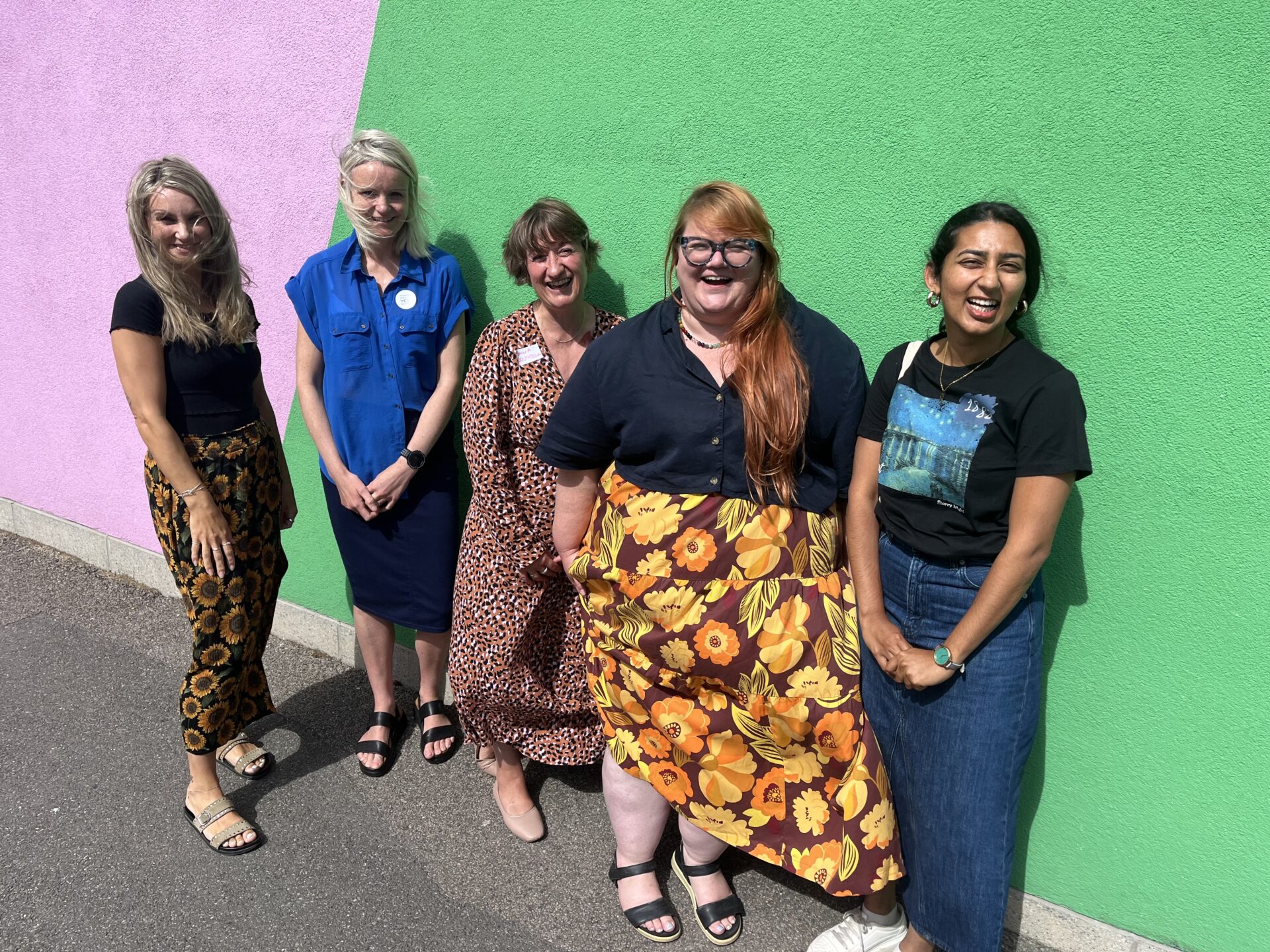 A group of 5 people smiling at the camera against the backdrop of Towner gallery, eastbourne